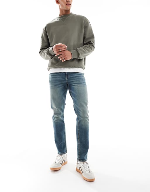 DESIGN slim jeans in mid wash blue with tint