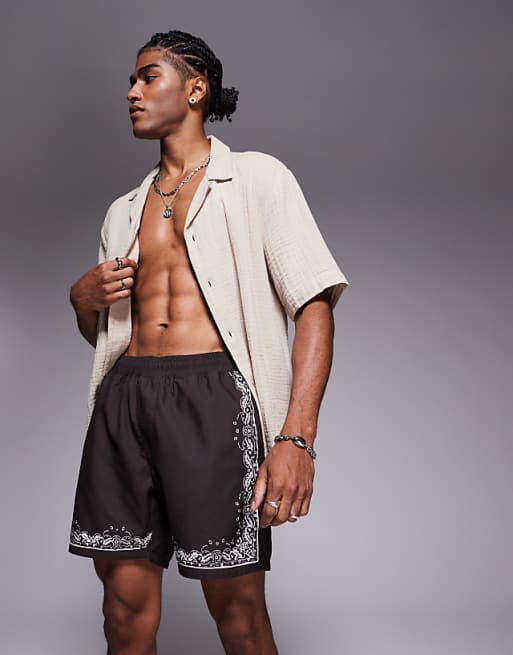 DESIGN swim shorts in mid length with border print in brown