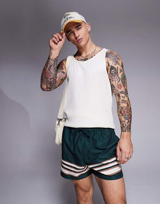 DESIGN swim shorts in short length in green with border stripe
