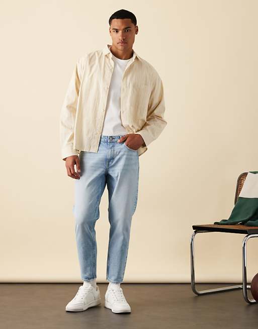 DESIGN tapered jeans in mid wash blue