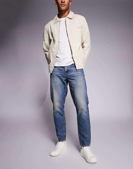 DESIGN tapered jeans in mid wash with tint