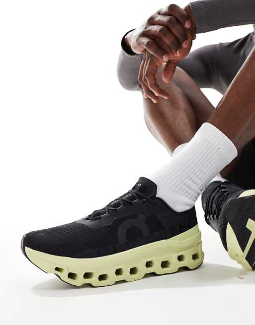 ON Cloudmonster running trainers in black and lime green